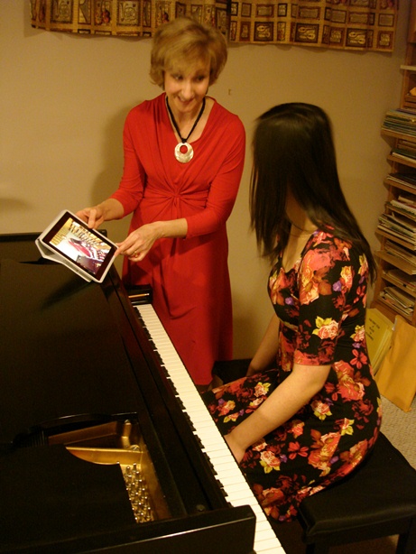 Jacqueline using an iPad to show a student a video